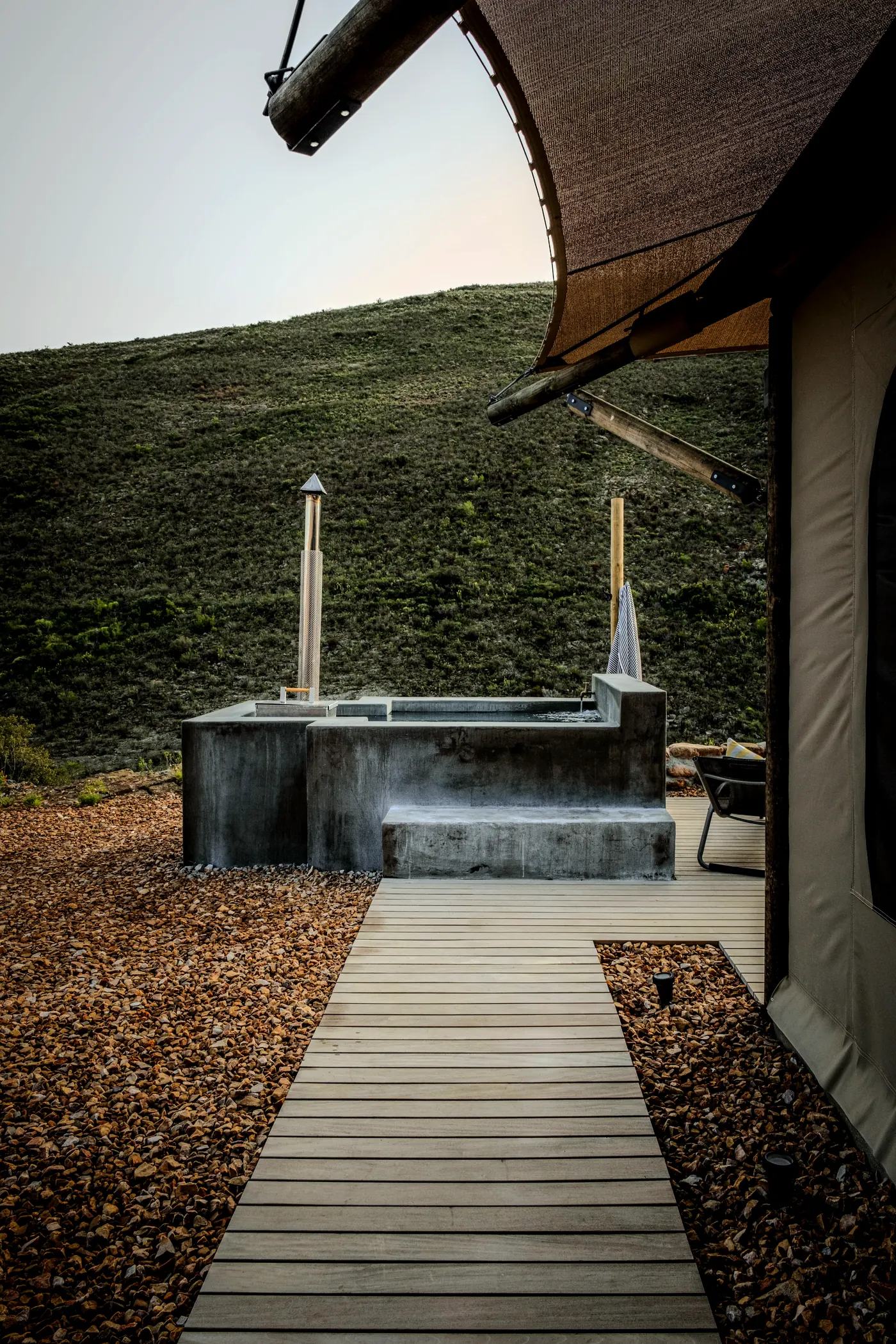 Private jacuzzi on the timber deck, heated by firewood, with the hills of the Baden Valley behind