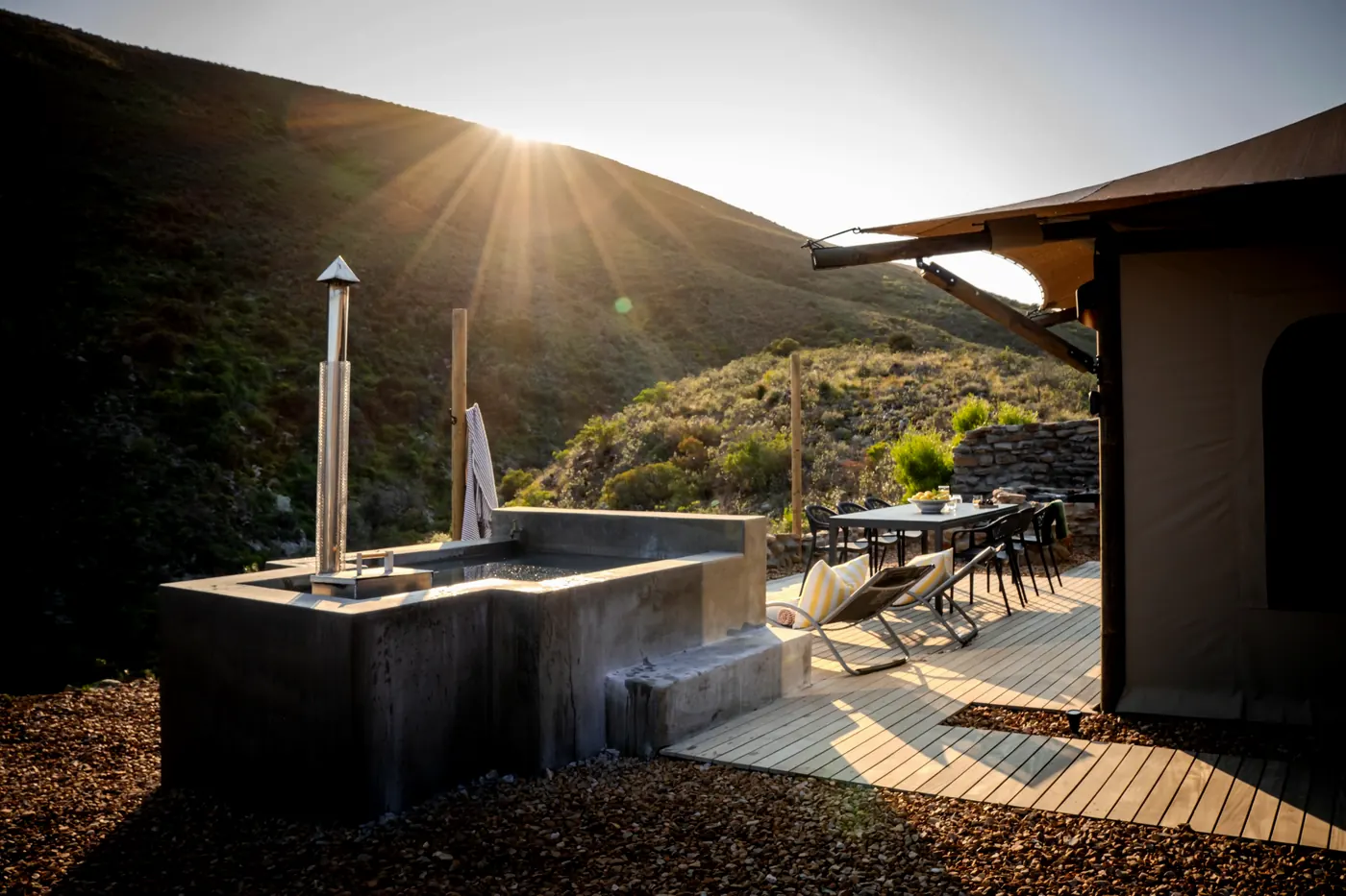 The deck and jacuzzi at golden hour, with the sun dropping behind the ridge above the Baden Valley